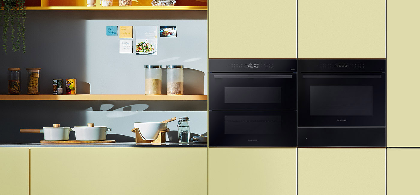 Dwa piekarniki Samsung wstawione do pomieszczenia urządzonego w żółto-niebieskich kolorach.