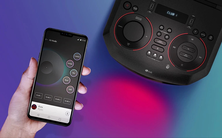 Ręka trzymająca smartfon obok urządzenia LG XBOOM widzianego z góry.