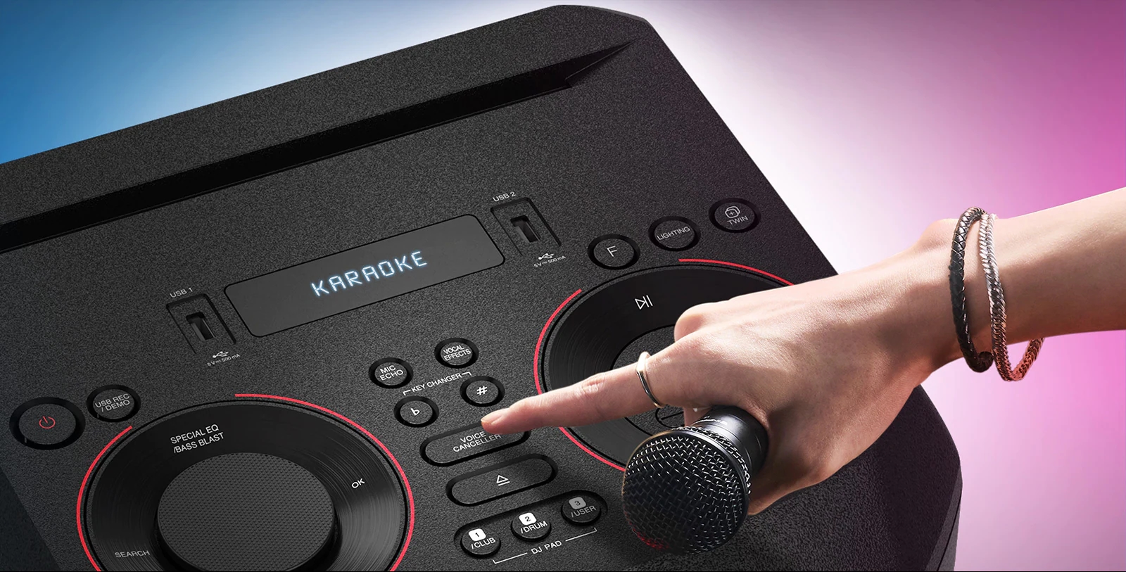 Ręka trzymająca mikrofon próbująca nacisnąć przycisk Voice Canceller u góry urządzenia LG XBOOM.