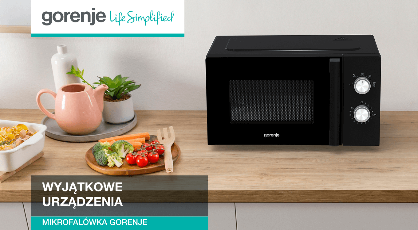 Biała kuchenka mikrofalowa marki Gorenje stojąca na drewnianym blacie kuchennym. Obok znajdują się warzywa na desce do krojenia oraz ceramiczny dzbanek. W lewym górnym rogu widoczne logo Gorenje z hasłem „Life Simplified”.