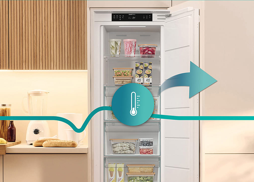 Otwarta zamrażarki Gorenje w nowoczesnej kuchni, z zaznaczonym symbolem termometru i strzałką – ilustracja równomiernej cyrkulacji chłodnego powietrza i utrzymania stabilnej temperatury wewnątrz.