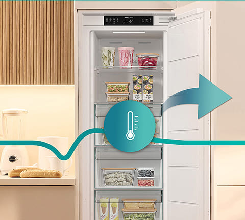 Otwarta zamrażarki Gorenje w nowoczesnej kuchni, z zaznaczonym symbolem termometru i strzałką – ilustracja równomiernej cyrkulacji chłodnego powietrza i utrzymania stabilnej temperatury wewnątrz.