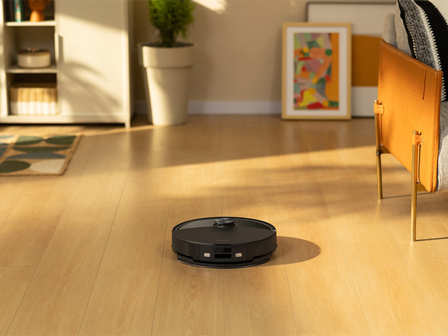 Kobieta obsługująca robota sprzątającego Roborock Q10 VF za pomocą smartfona w salonie