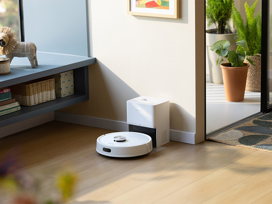 Robot sprzątający Roborock Q7 TF White wraca do stacji dokującej przy ścianie w jasnym, przytulnym wnętrzu