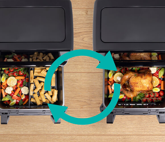 Dwa kosze frytkownicy beztłuszczowej z różnymi potrawami i dużą turkusową ikoną strzałek w kółko, symbolizującą funkcję wymiany lub synchronizacji gotowania.