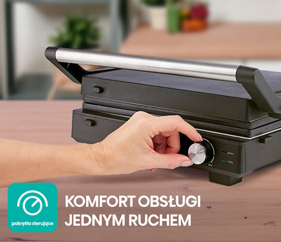 Obrazek przedstawia czarny elektryczny grill z metalowym uchwytem, na którym widoczna jest ręka obracająca pokrętło na panelu sterującym. Tło jest lekko rozmyte, co sugeruje, że scena ma miejsce w kuchni. Po lewej stronie obrazu znajduje się logo w kolorze turkusowym, przypominające wskaźnik prędkości, co może wskazywać na funkcjonalność i nowoczesność urządzenia. Całość emanuje wrażeniem komfortu i łatwości obsługi.