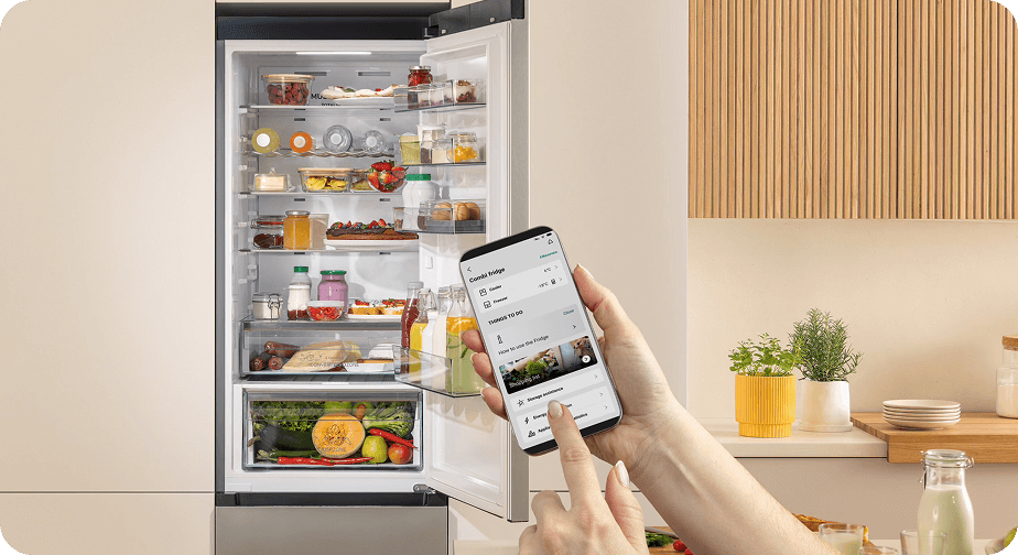 Otwarta lodówka Gorenje z pełnym wnętrzem, sterowana bezprzewodowo za pomocą aplikacji na smartfonie