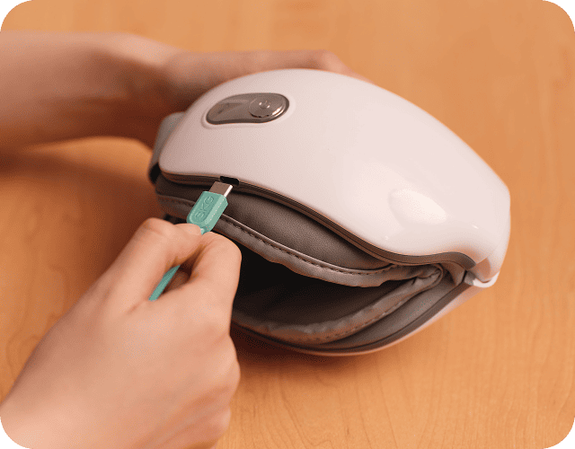 Ładowanie złożonego masażera oczu SKG ES500 za pomocą turkusowej wtyczki USB (Universal Serial Bus) typu C