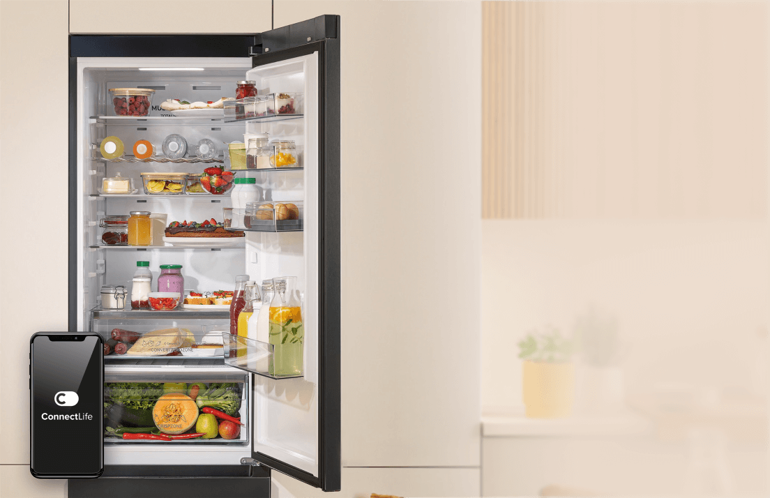 Otwarta chłodziarka Gorenje BigVolume wypełniona produktami oraz ekran smartfona z nazwą aplikacji ConnectLife