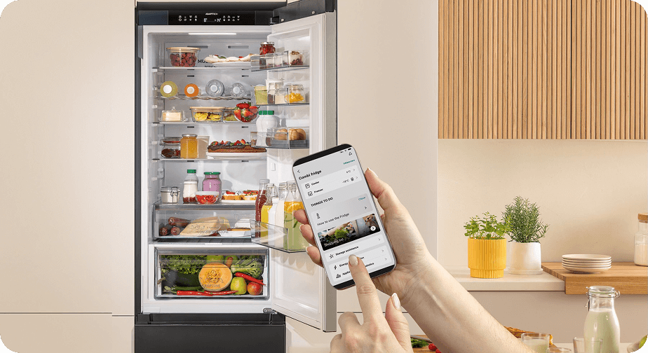 Otwarta lodówka Gorenje z pełnym wnętrzem, sterowana bezprzewodowo za pomocą aplikacji na smartfonie