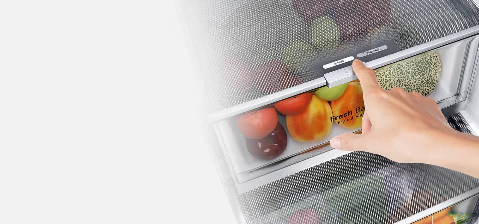 Dolne szuflady lodówki są wypełnione kolorowymi produktami spożywczymi. Zdjęcie we wstawce pokazuje w powiększeniu dźwignię wyboru optymalnego poziomu wilgotności pozwalającego utrzymać świeżość produktów.
