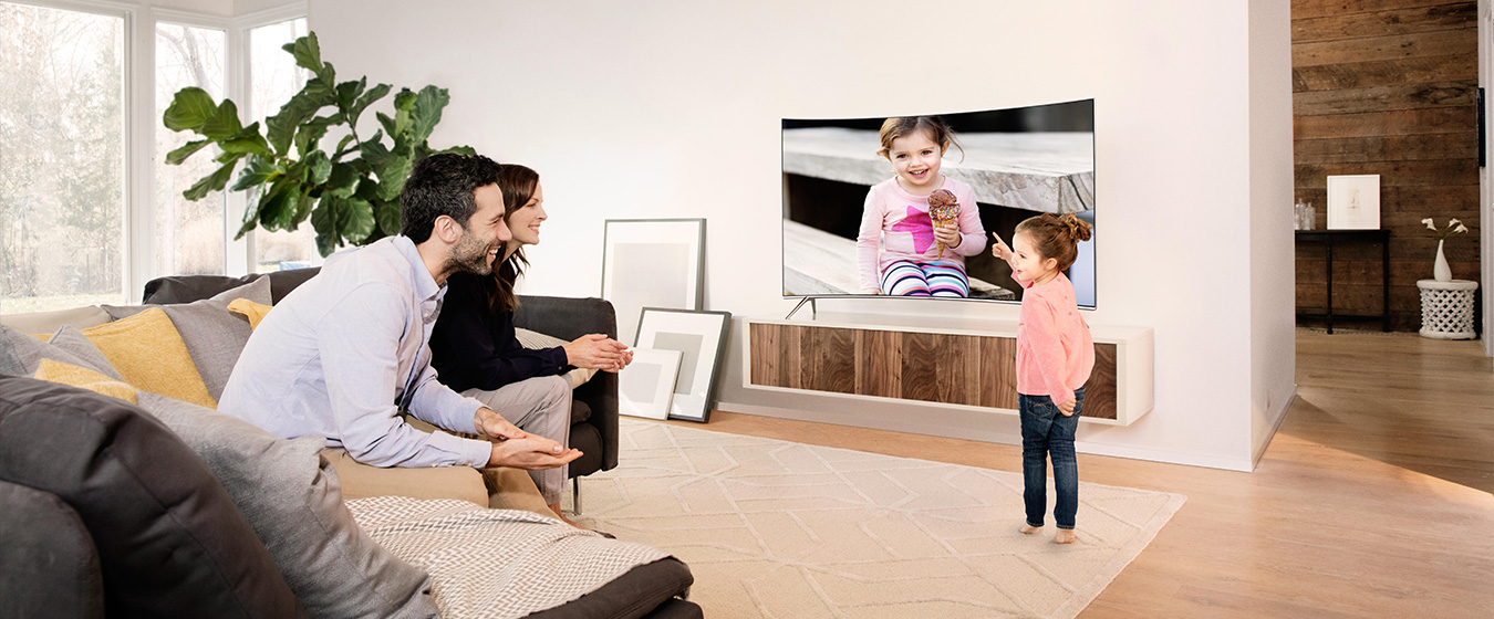 Wzornictwo: Uśmiechnięta rodzina przed SUHD TV w salonie
