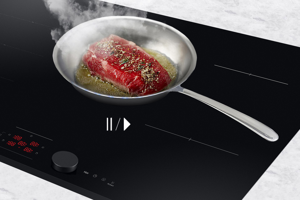 Smażące się mięso na metalowej patelni - płyta indukcyjna Samsung NZ85C6058GK 