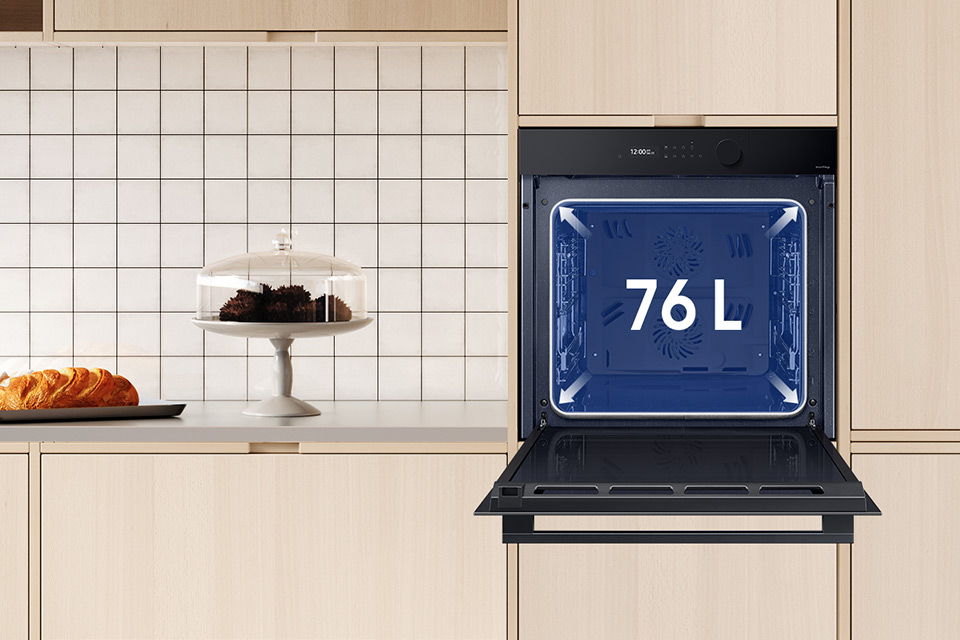 Na zdjęcie piekarnika Samsung NV7B5660XAK umieszczonego w jasnej zabudowie meblowej nałożono grafikę informującą o pojemności komory urządzenia wynoszącej aż 76 litrów