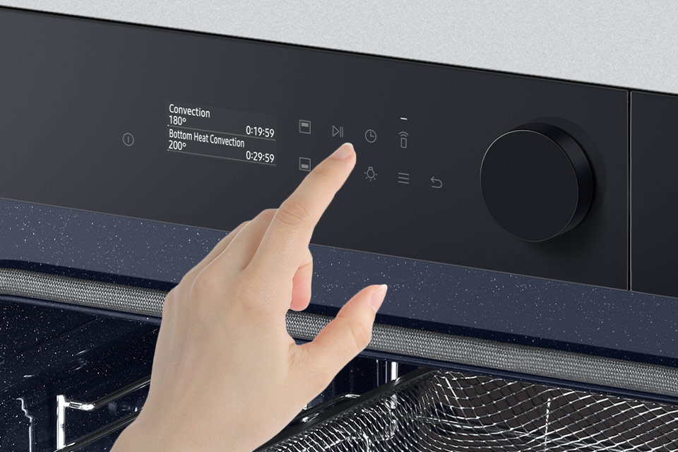 Zdjęcie dłoni sięgającej do ikony blokady ilustruje zabezpieczenie panelu sterowania piekarnika Samsung
