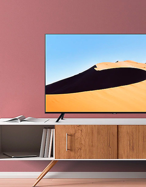 Fragment telewizora Samsung stojącego na biało-drewnianej szafce RTV