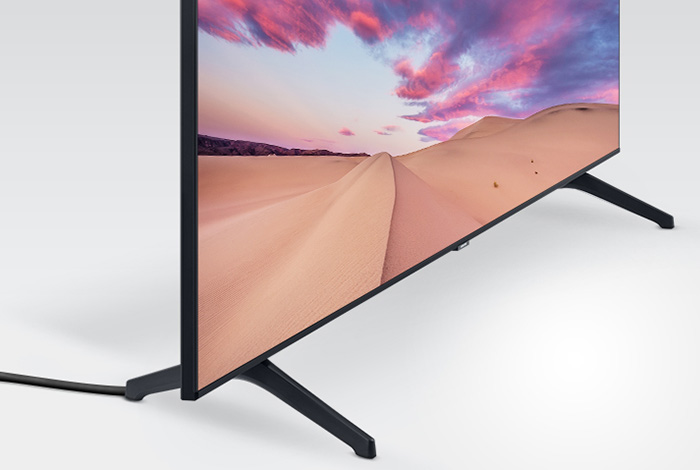 Telewizor stojący w białej minimalistycznej przestrzeni, ukryte kable