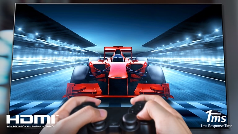 Zbliżenie na gracza grającego w grę wyścigową na ekranie telewizora. W lewym dolnym rogu obrazu znajduje się logo HDMI, a w prawym dolnym rogu – 1ms czasu reakcji.