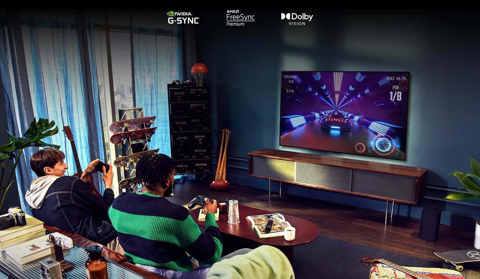 Dwie osoby siedzące na kanapie i grające w grę wyścigową przy użyciu kontrolera na telewizorze LG OLED serii G2 w salonie