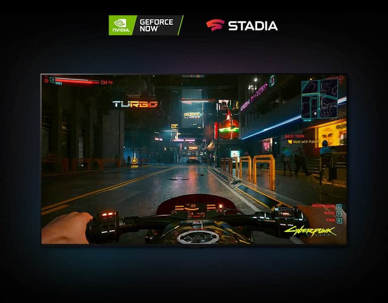 W scenie z gry Cyberpunk 2077 pokazanej na ekranie telewizora LG OLED gracz jedzie oświetloną neonami ulicą na motocyklu