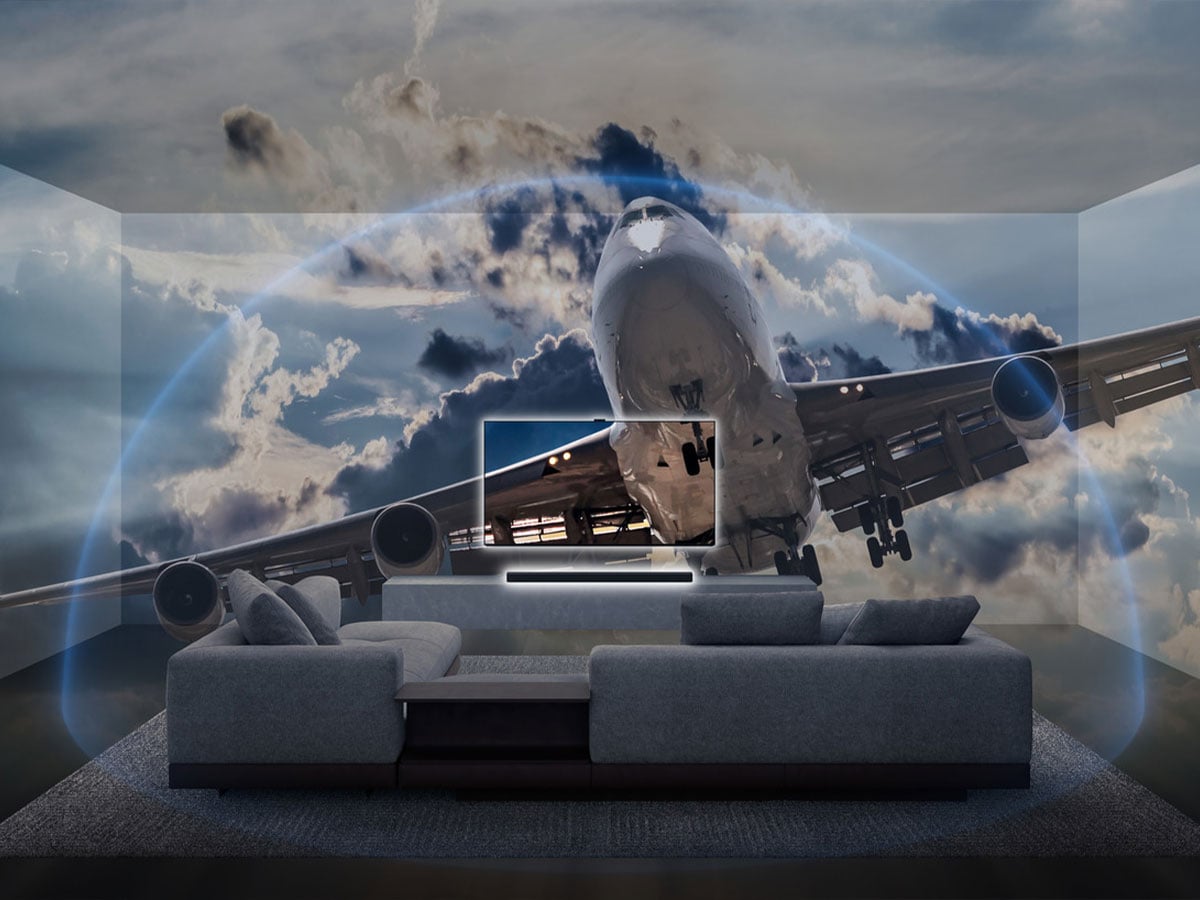 Salon z telewizorem BRAVIA i systemem audio; obraz lasu tropikalnego z latającymi papugami ilustruje immersyjny dźwięk Dolby Atmos i DTS:X.