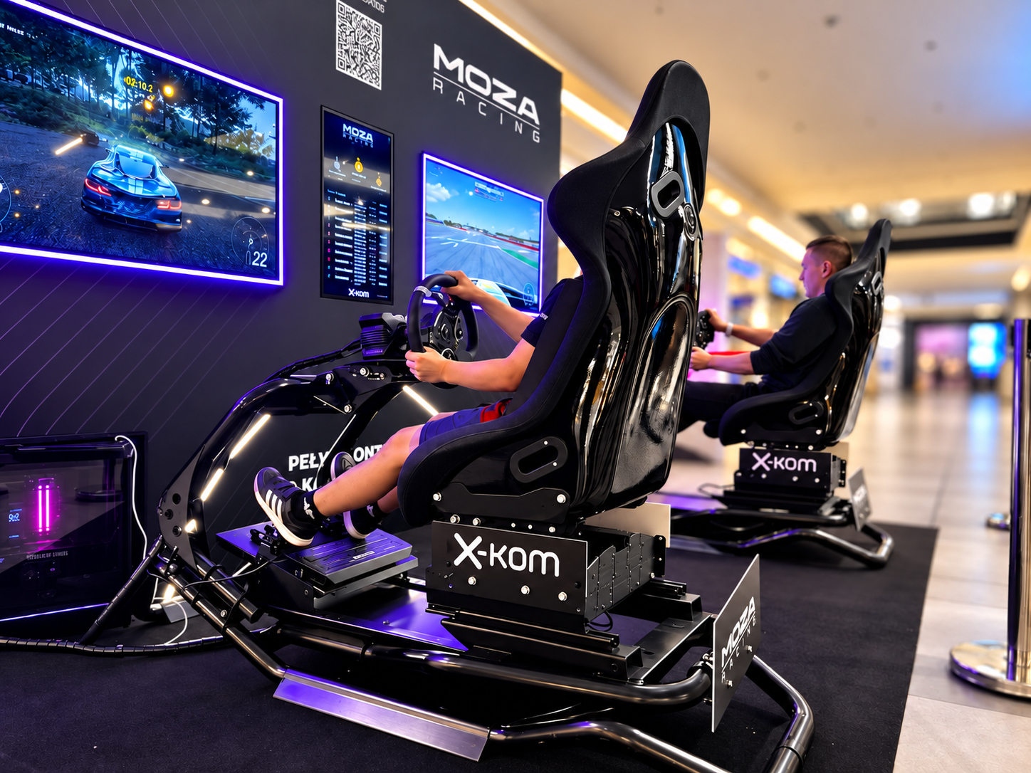 Stanowiska MOZA Racing z fotelami wyścigowymi w salonie x-kom