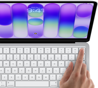 MacBook Neo w kolorze srebrnym z widocznym ekranem logowania i palcem osoby używającej czytnika Touch ID w prawym górnym rogu klawiatury